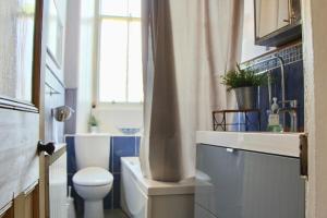 a bathroom with a toilet and a sink and a window at Classic Edinburgh Flat in the heart of Morningside in Edinburgh