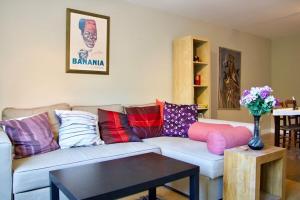 a living room with a couch with colorful pillows at Bright Spacious 2 Bedroom Apartment in Stockbridge in Edinburgh