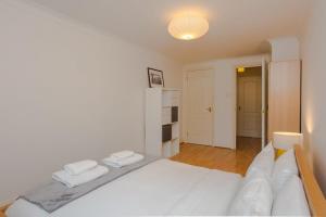 a bedroom with a white bed with two towels on it at Contemporary 1Bedroom Flat in Camberwell Oval in London