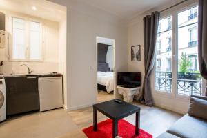 sala de estar con cocina y dormitorio con cama en Modern arty flat close to Saint-Germain des Près, en París