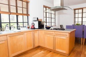 a kitchen with wooden cabinets and a stove top oven at Spectacular Central 4-Bedroom Close To London Eye in London