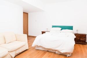 a white bedroom with a bed and a couch at Spectacular Central 4-Bedroom Close To London Eye in London