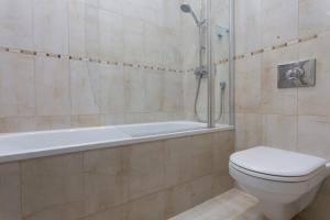 a bathroom with a shower and a toilet and a tub at Bright and Spacious 1 Bedroom Apartment in the Heart of Kensington in London