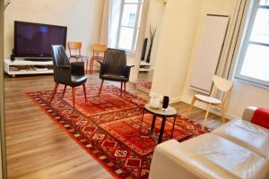 a living room with chairs and a red rug at 1 Bedroom Apartment in the Heart of the Marais area in Paris