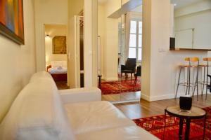 パリにある1 Bedroom Apartment in the Heart of the Marais areaのリビングルーム(白いソファ付)、ベッドルーム1室