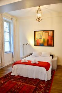 a bedroom with a large bed with a red rug at 1 Bedroom Apartment in the Heart of the Marais area in Paris