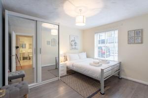Habitación blanca con cama y ventana en Stylish and Homely 4 Bedroom Home in East London en Londres