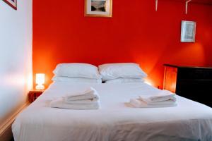 a red bedroom with a white bed with towels on it at Traditional Apartment oer the Meadows in Edinburgh