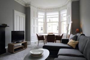 エディンバラにあるStylish 2 Bedroom Bruntsfield Apartment in Edinburghのリビングルーム(ソファ、テーブル付)