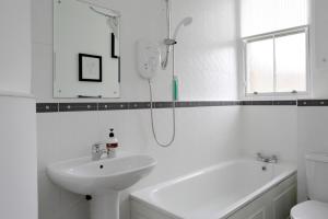 エディンバラにあるStylish 2 Bedroom Bruntsfield Apartment in Edinburghの白いバスルーム(シャワー、シンク付)