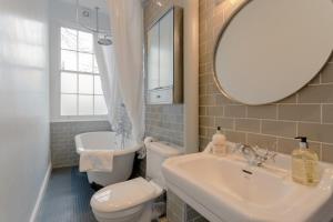 Vibrant 1 Bedroom Flat In Islington With Garden في لندن: حمام مع مرحاض ومغسلة ومرآة