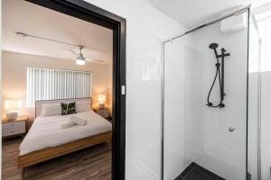 a bedroom with a bed and a glass shower at Stylish Apartment in Leafy South Perth in Perth