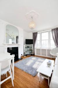 a living room with a white couch and a table at Stylish 2 Bedroom Apartment Between Camden Town Primrose Hill in London