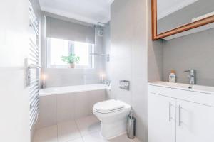y baño blanco con aseo y bañera. en Modern 3 Bedroom Apartment in Brixton en Londres