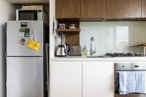 een witte keuken met een koelkast en een wastafel bij Eclectic 1 Bedroom South Yarra Hideaway in Melbourne