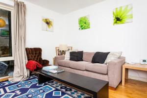 a living room with a couch and a table at Charming Peaceful 2 Bedroom with Parking and Garden in London