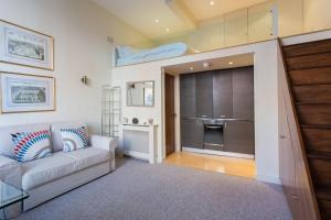 Modern 1 bed Flat in Knightsbridge في لندن: غرفة معيشة مع أريكة ومطبخ