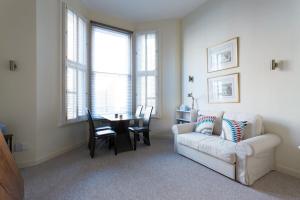 Modern 1 bed Flat in Knightsbridge في لندن: غرفة معيشة مع أريكة بيضاء وطاولة