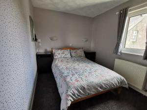 a small bedroom with a bed and a window at Whitehouse Guest House in Stirling