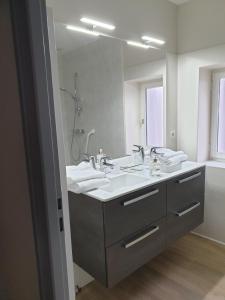 La salle de bains est pourvue de 2 lavabos et d'un grand miroir. dans l'établissement A l'appartement chez REVIGORA, à Vienne