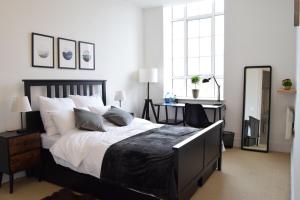 a bedroom with a large bed and a desk at Bright Warehouse Conversion in Buzzing Peckham in London