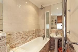 a bathroom with a tub and a sink at Bright 2 Bedroom Flat in Central London in London