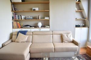 a living room with a couch and bookshelves at Fully Renovated Bright Studio With High View in Paris