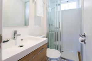 bagno con lavandino e doccia in vetro di Sunlit photographers 1Bedroom Apartment in Alcântara a Lisbona