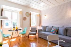 un soggiorno con divano, tavolo e sedie di Sunlit photographers 1Bedroom Apartment in Alcântara a Lisbona