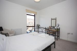 sypialnia z łóżkiem, biurkiem i oknem w obiekcie Fantastic Modern 2 Bedroom Flat in Lambeth w Londynie
