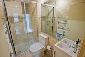 a bathroom with a shower and a toilet and a sink at Thistle Street Apartment at Heart of the City Centre in Edinburgh