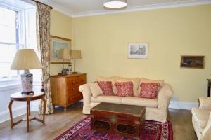 a living room with a couch and a table at Thistle Street Apartment at Heart of the City Centre in Edinburgh