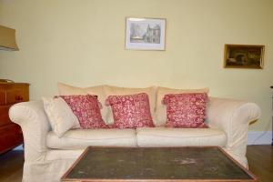 a couch with pillows on it in a living room at Thistle Street Apartment at Heart of the City Centre in Edinburgh