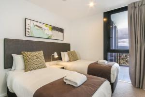 een hotelkamer met 2 bedden en een raam bij Luxurious 2 Bedroom Brand New Apartment With Amazing Hinterland Views in Gold Coast