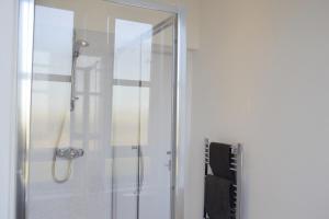 La salle de bains est pourvue d'une douche avec une porte en verre. dans l'établissement Modern 1 Bedroom Flat In the Heart of Edinburgh, à Édimbourg