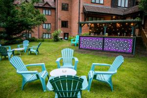 un grupo de sillas y una mesa en un patio en The Casa Hotel-Yateley, Farnborough, en Yateley