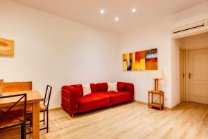 バルセロナにあるModernl 2 Bedroom in the fantastic Sant Antoni areaのリビングルーム(赤いソファ、テーブル付)