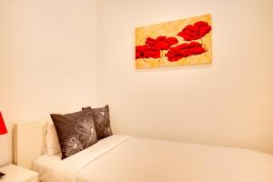 バルセロナにあるModernl 2 Bedroom in the fantastic Sant Antoni areaのベッドルーム1室(ベッド1台付)が備わります。壁には絵画が飾られています。