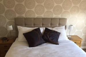 a bedroom with a white bed with two pillows at Modern Apartment in Edinburgh in Edinburgh