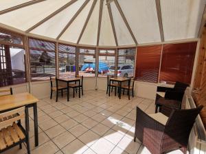 a dining room with tables and chairs and windows at Whitehouse Guest House in Stirling