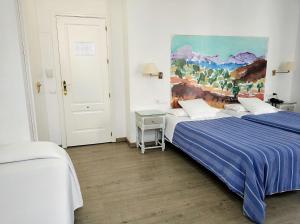 um quarto com duas camas e um quadro na parede em Ronda Hotel Polo em Ronda