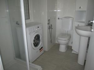 a bathroom with a washing machine and a toilet at Appartamento Pineta in Grado +72 photos