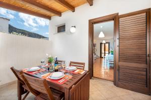 uma sala de jantar com uma mesa e cadeiras e uma porta em Carlottas Home em San Vito lo Capo
