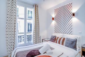 a white bedroom with a bed and a window at 23 - Pretty Parisian Flat in Montorgueil in Paris