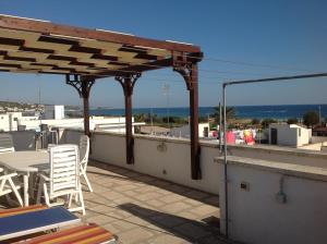 a patio with chairs and tables on a roof at Casa vacanze a Pescoluse (80 mt dal mare) in Marina di Pescoluse