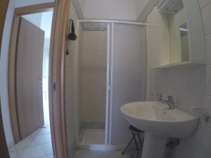 bagno bianco con lavandino e doccia di Casa vacanze a Pescoluse (80 mt dal mare) a Marina di Pescoluse