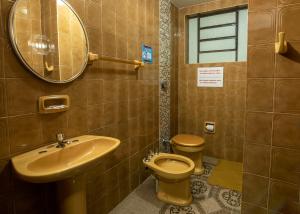 a bathroom with a sink and a toilet and a mirror at Classic Hotel e Motel in Santa Cruz do Sul