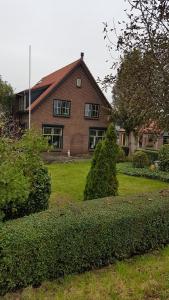 a house with a yard with bushes in front of it at Bed bij Boertje in Pijnacker