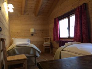 a bedroom with two beds and a window at B&B La Locanda in Macugnaga