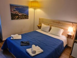 a bedroom with a bed with hats and towels on it at Estrada De Benfica 600 Apartamentos in Lisbon
